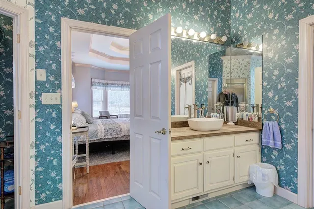 a en suite bathroom with a granite countertop sink and mirror
