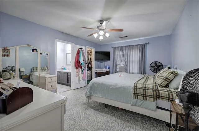 a bedroom with bed a mirror and desk