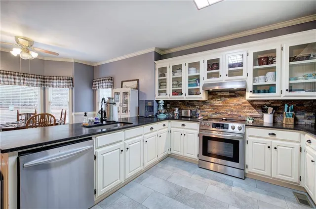 a kitchen with stainless steel appliances granite countertop a stove sink and cabinets