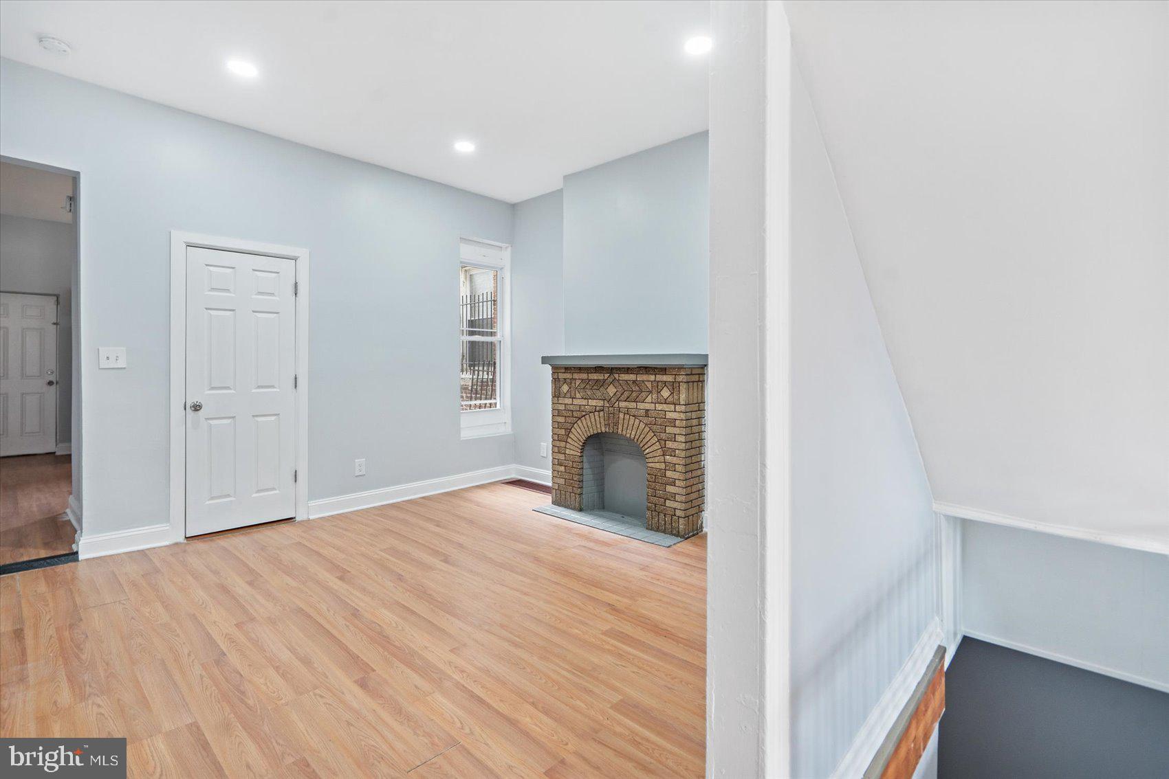 1604 North Broadway Baltimore, MD 21213 - Photo 12 of 39 a view of an empty room with wooden floor and a window