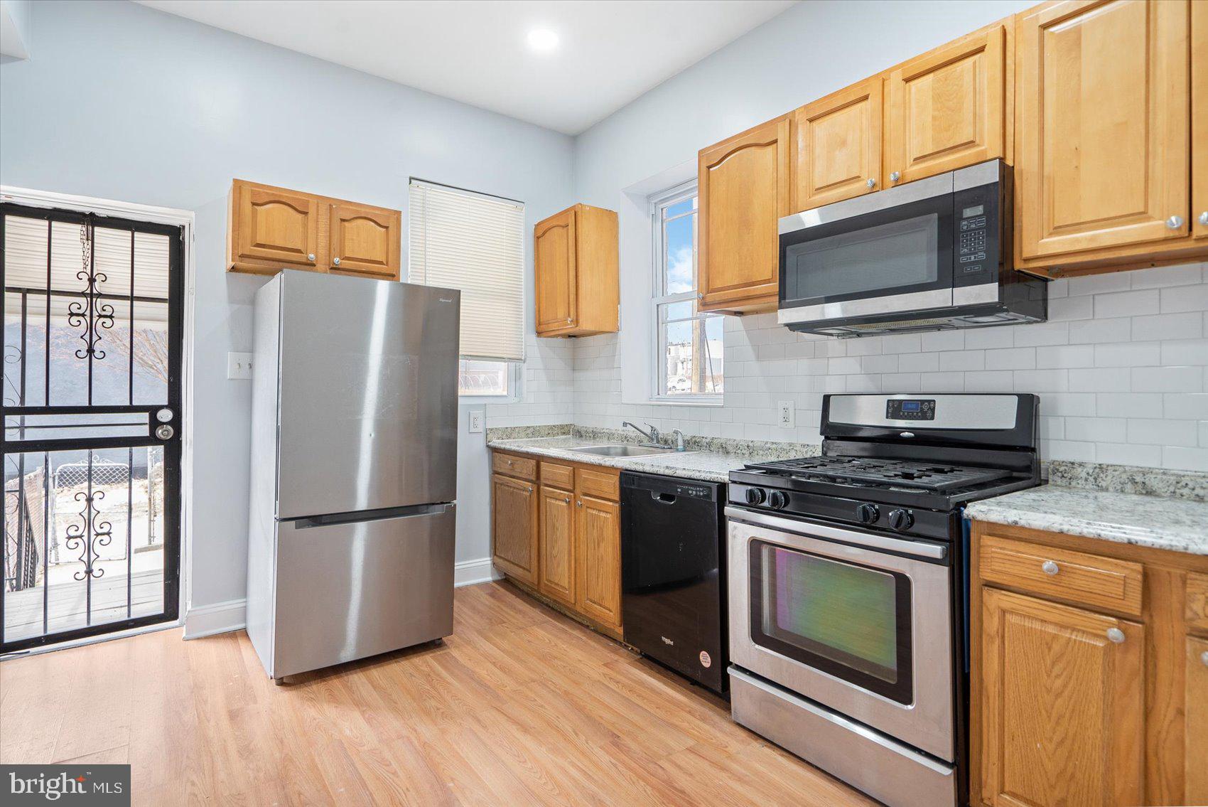 1604 North Broadway Baltimore, MD 21213 - Photo 15 of 39 a kitchen with stainless steel appliances granite countertop a refrigerator stove and microwave