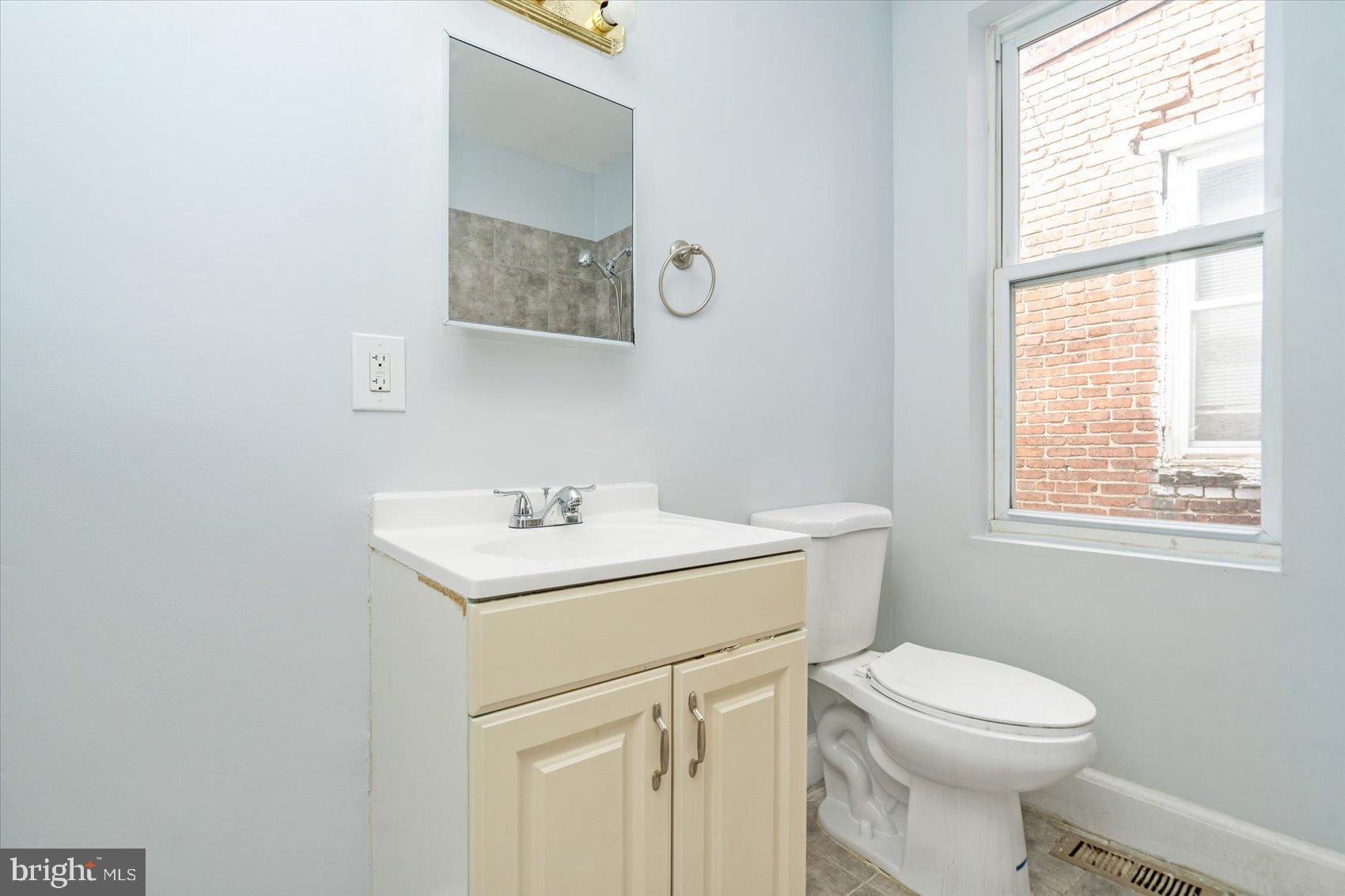 1604 North Broadway Baltimore, MD 21213 - Photo 26 of 39 a bathroom with a toilet sink and mirror