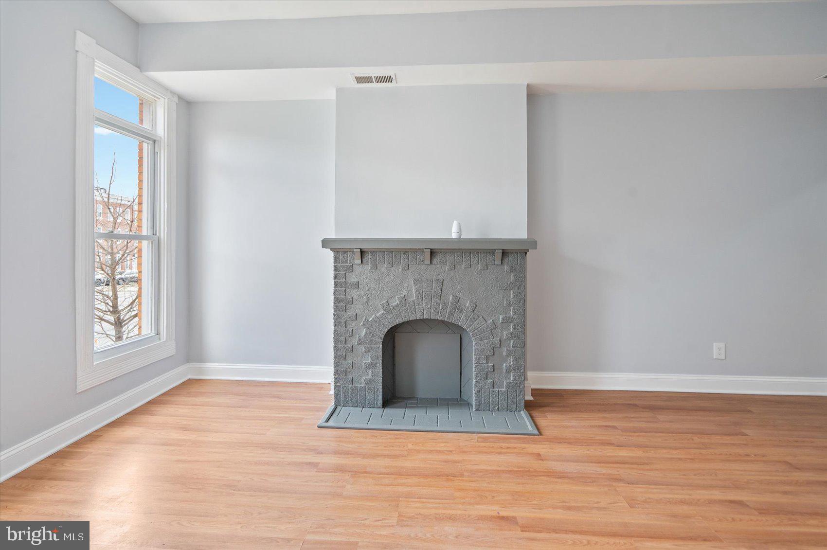 1604 North Broadway Baltimore, MD 21213 - Photo 7 of 39 a view of an empty room with wooden floor and a window