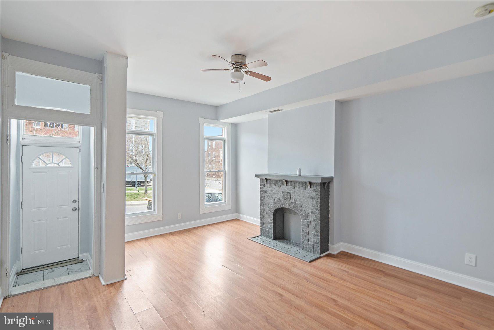 1604 North Broadway Baltimore, MD 21213 - Photo 9 of 39 wooden floor fireplace and windows in an empty room