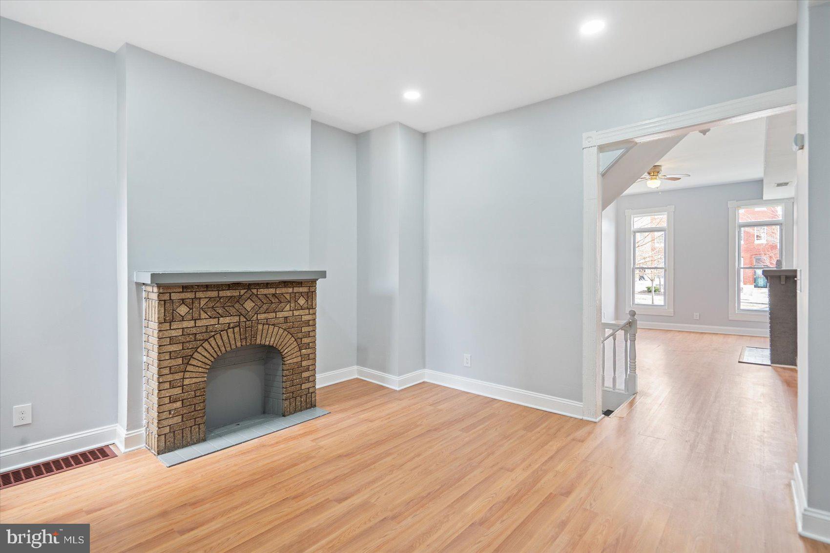 1604 North Broadway Baltimore, MD 21213 - Photo 10 of 39 a view of an empty room with wooden floor and a fireplace