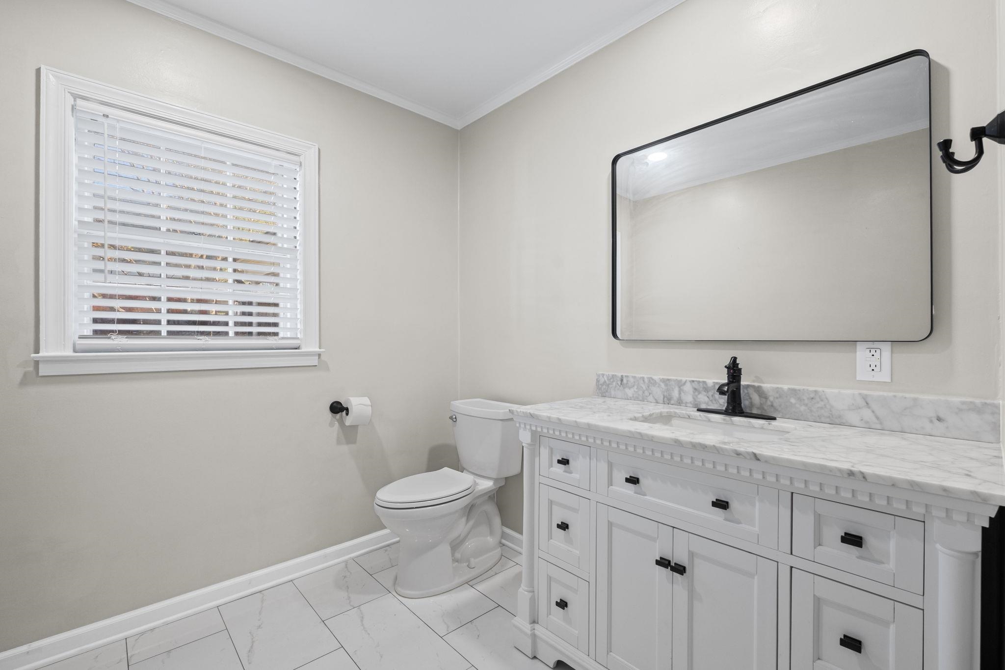 88 North Reese Street Memphis, TN 38111 - Photo 20 of 40 a bathroom with a granite countertop toilet a sink and a mirror