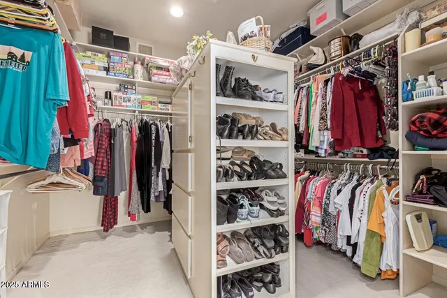 a view of walk in closet with clothes and shoes