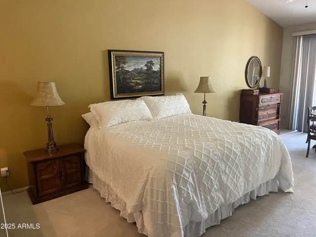 a large bed sitting in a bedroom and a lamp