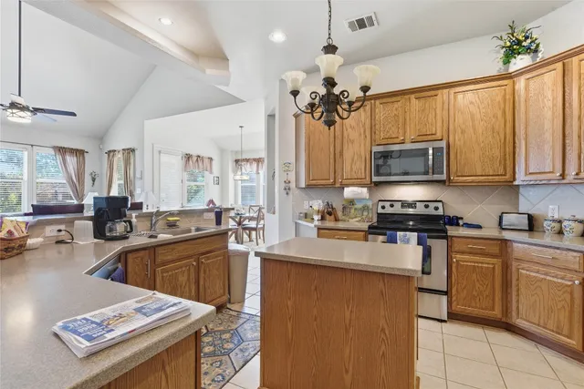 a kitchen with kitchen island granite countertop a sink appliances cabinets and a counter top space