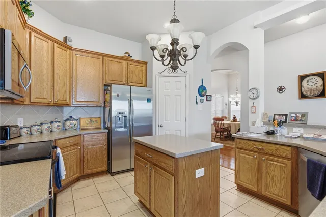 a kitchen with kitchen island granite countertop stainless steel appliances a sink stove and refrigerator