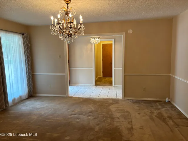 a view of a hallway with windows and chandelier