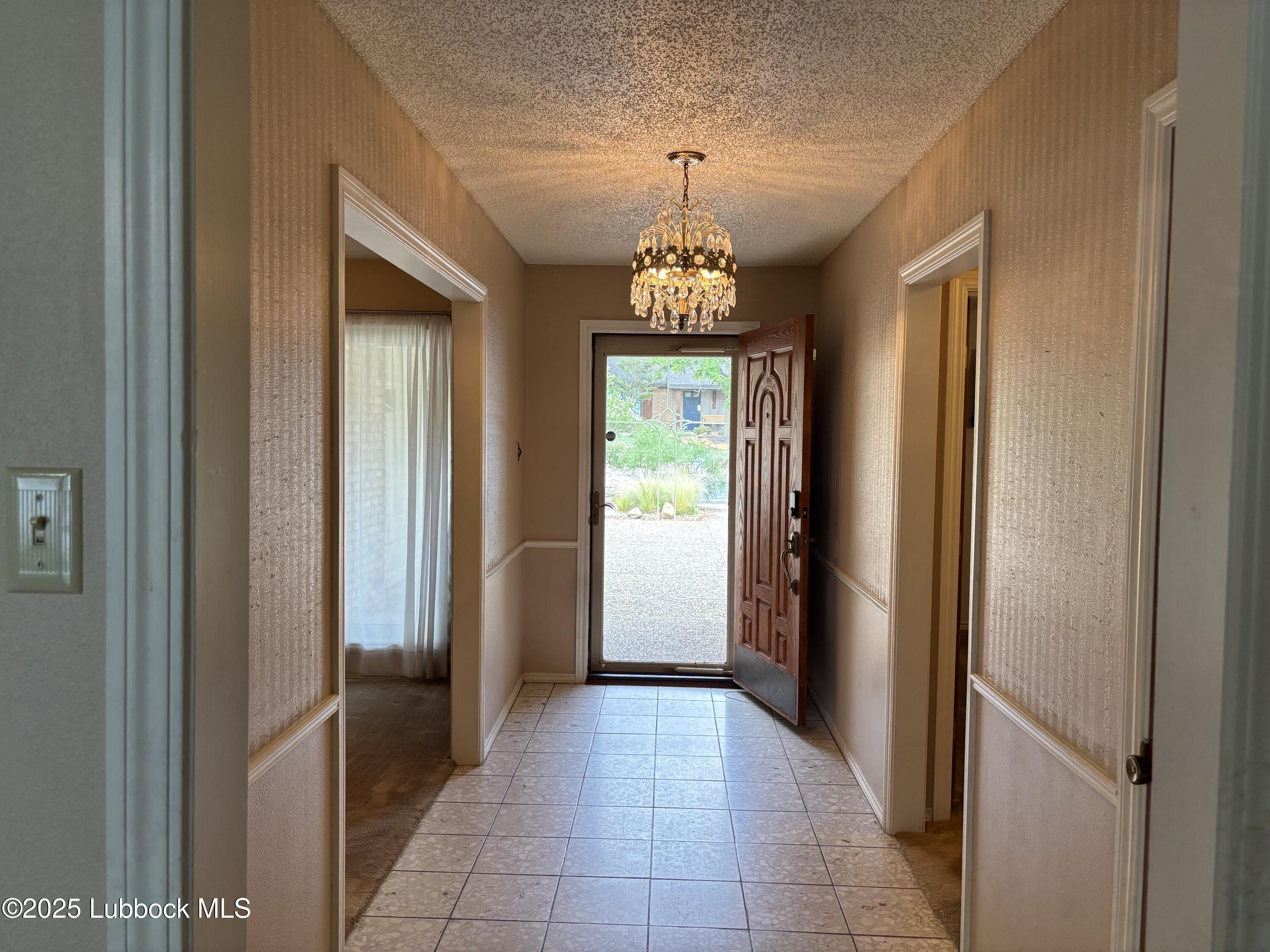 53 East Lakeshore Drive Ransom Canyon, TX 79366 - Photo 16 of 43 a view of a hallway with windows and chandelier