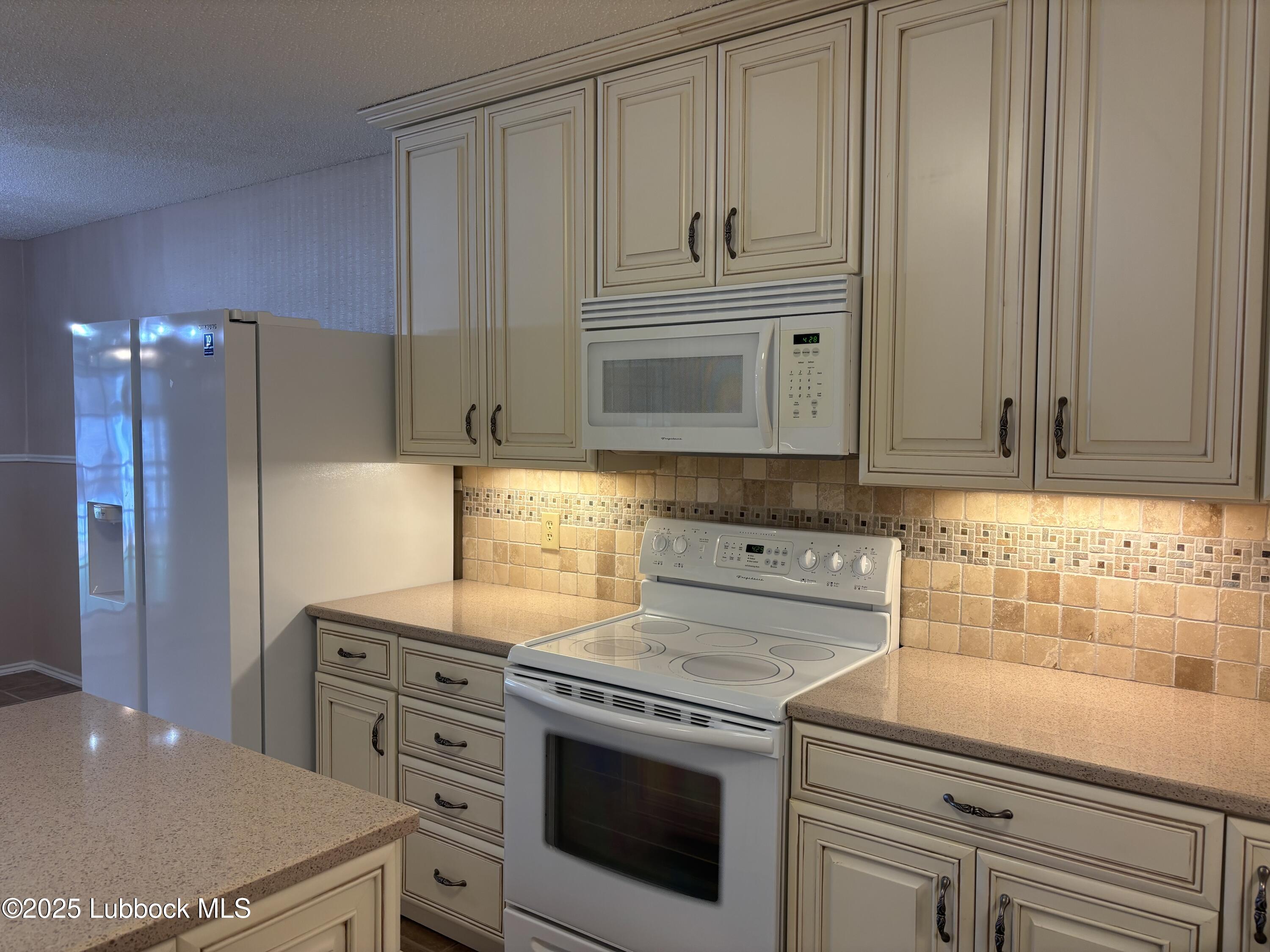 53 East Lakeshore Drive Ransom Canyon, TX 79366 - Photo 21 of 43 a kitchen with granite countertop white cabinets and white appliances