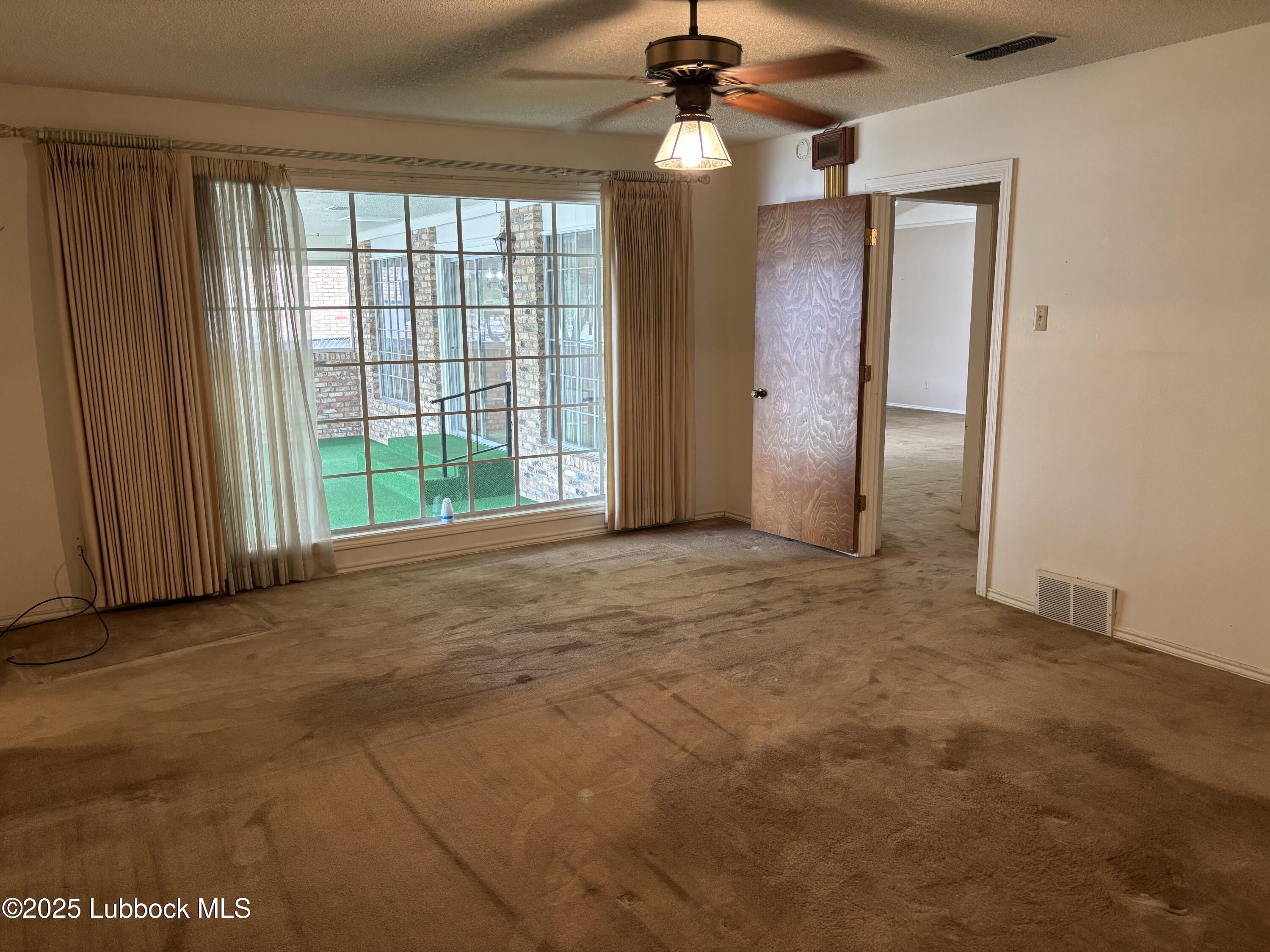 53 East Lakeshore Drive Ransom Canyon, TX 79366 - Photo 25 of 43 an empty room with windows and fan