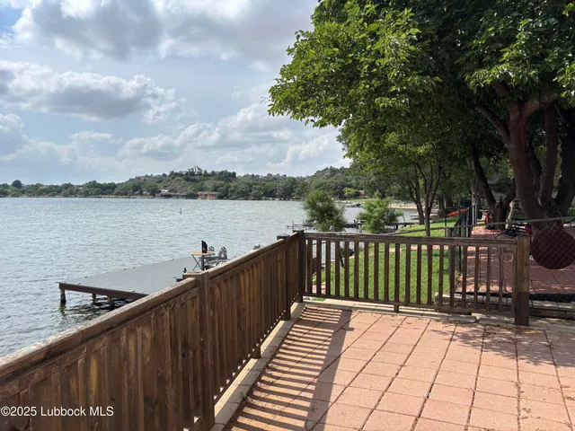 a balcony with wooden floor and lake view