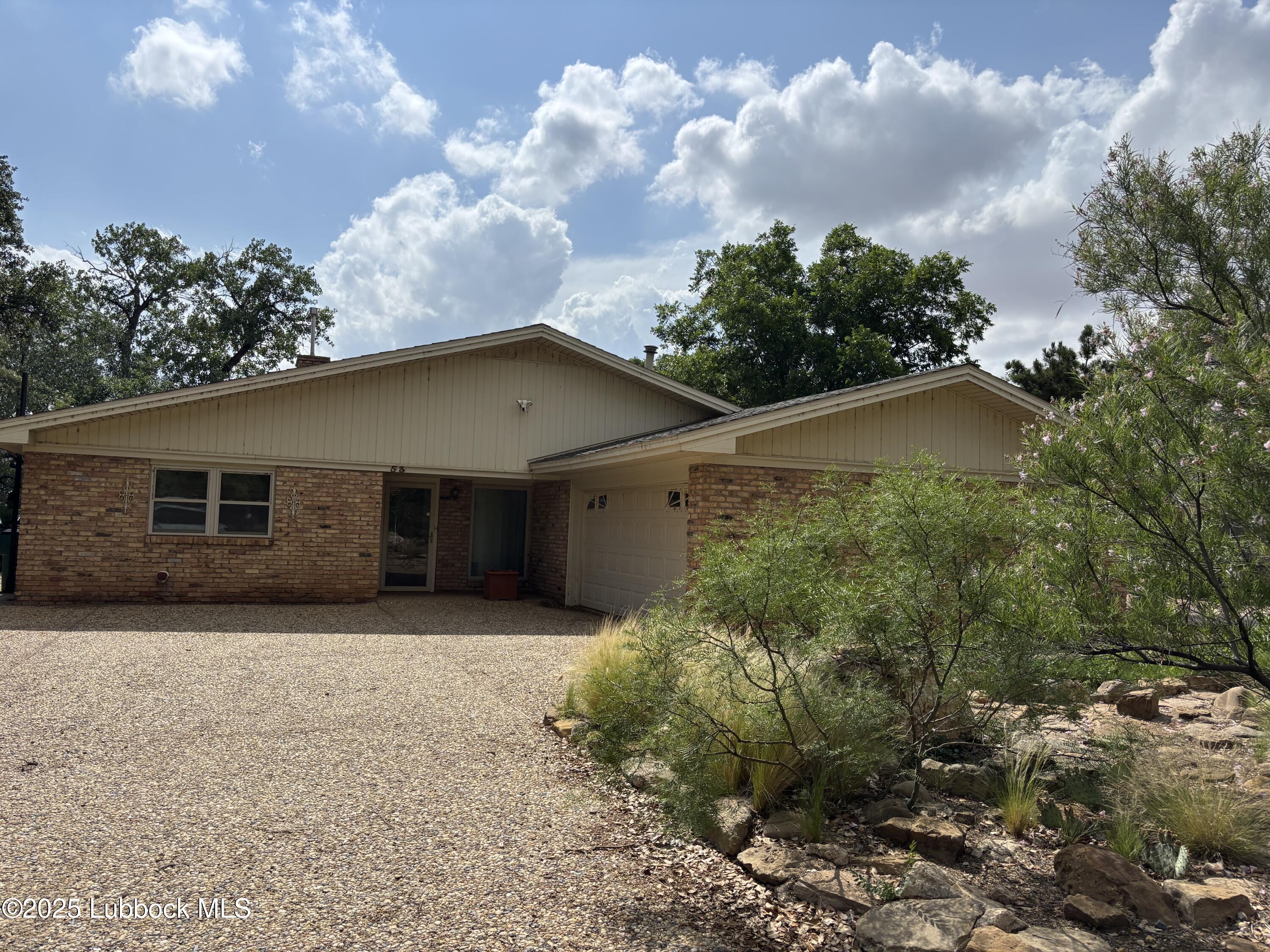 53 East Lakeshore Drive Ransom Canyon, TX 79366 - Photo 4 of 43 a front view of house with yard and trees in the background