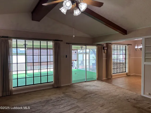 a view of a livingroom with a ceiling fan and window
