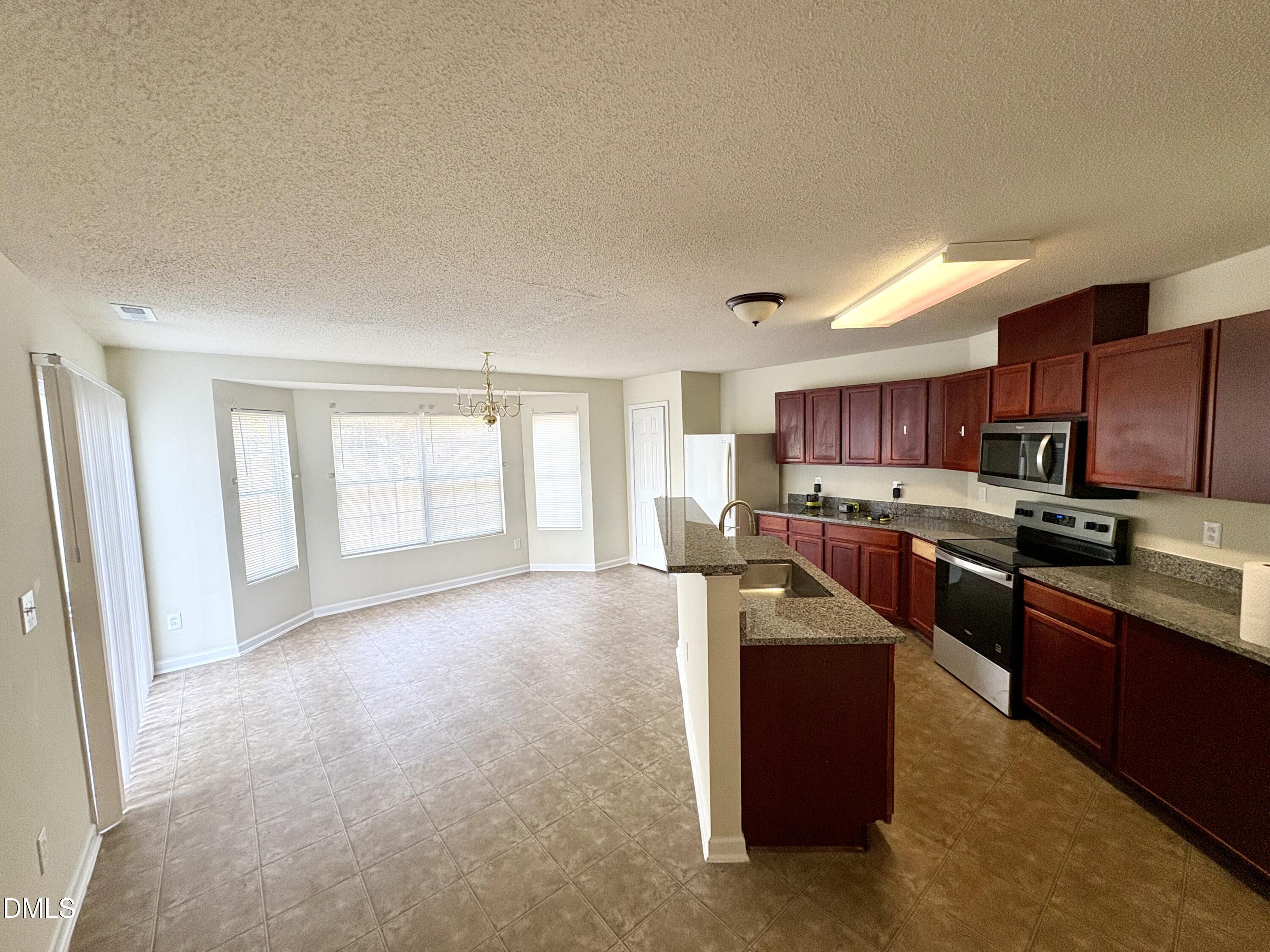 2422 Quarry Ridge Lane Raleigh, NC 27610 - Photo 3 of 10 a large kitchen with stainless steel appliances granite countertop a refrigerator a sink a stove a microwave a counter space and cabinets