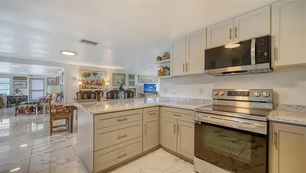 a kitchen with kitchen island granite countertop a sink stainless steel appliances and cabinets