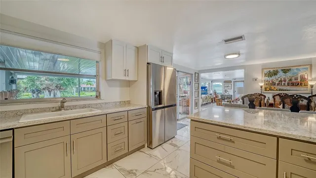 a bathroom with a granite countertop sink and a large mirror next to a yard