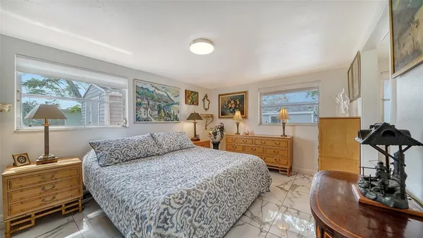 a bedroom with a bed and a lamp on dresser