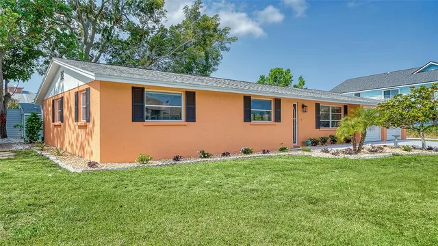 a front view of house with yard and trees in the background