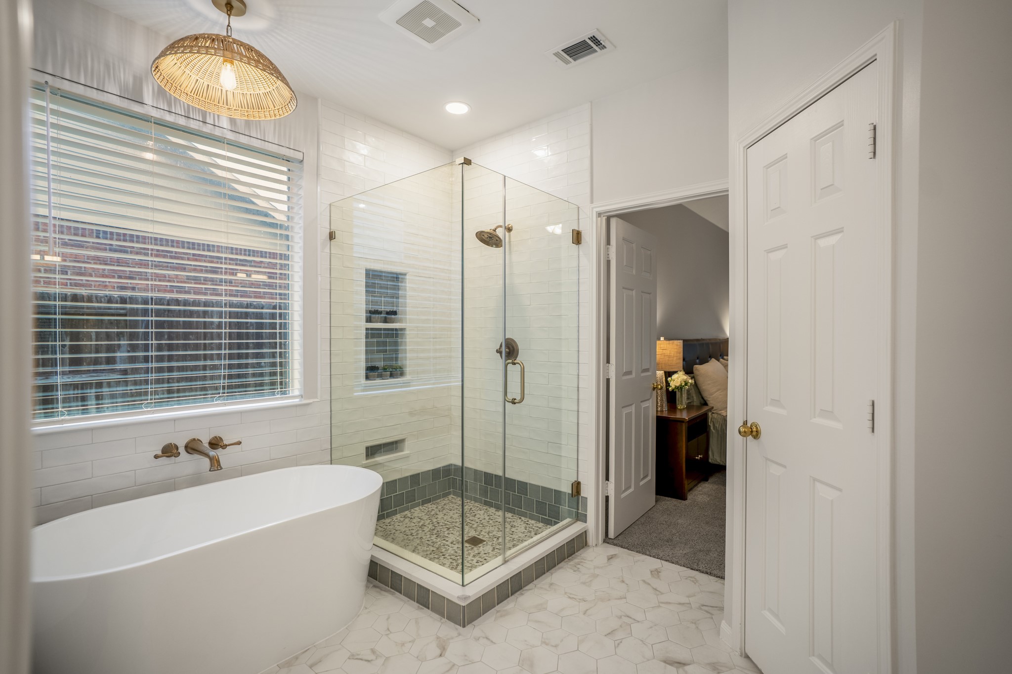 6311 Sparrows Glen Lane Spring, TX 77379 - Photo 22 of 50 The redesigned shower features a glass surround, layered tilework, built-in niches, and a soaking tub set beneath the window—plus a view back into the primary bedroom to show how the suite connects.