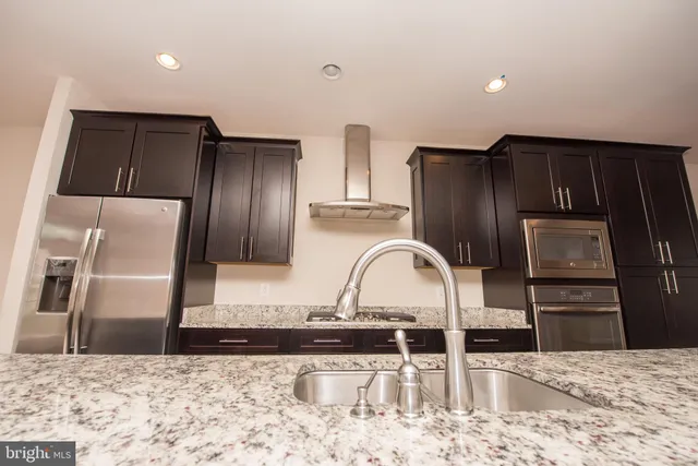 a kitchen with granite countertop a refrigerator and a sink