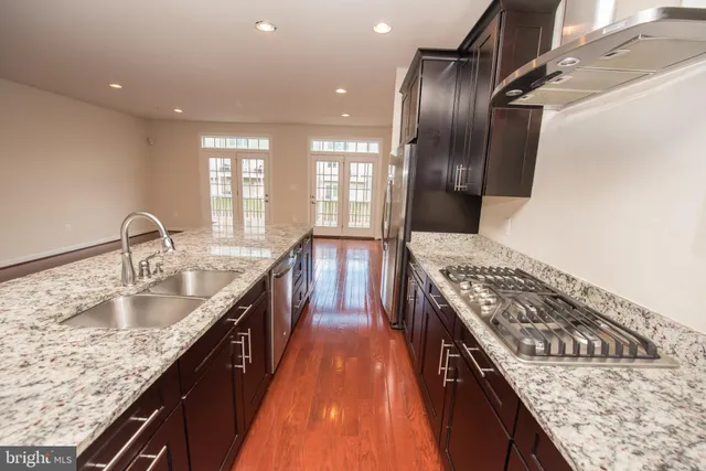 a kitchen with kitchen island granite countertop a sink stove and refrigerator