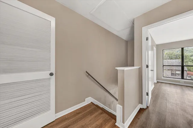 a view of hallway with stairs and wooden floor