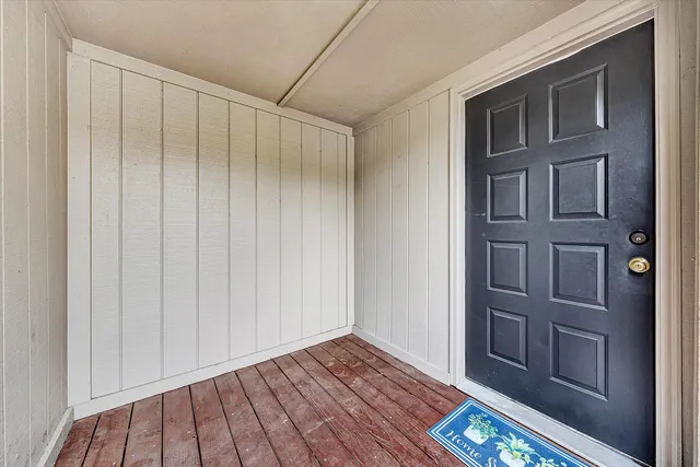 a view of an empty room with wooden floor and a cabinet