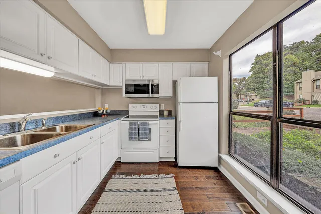 a kitchen with white cabinets and white appliances