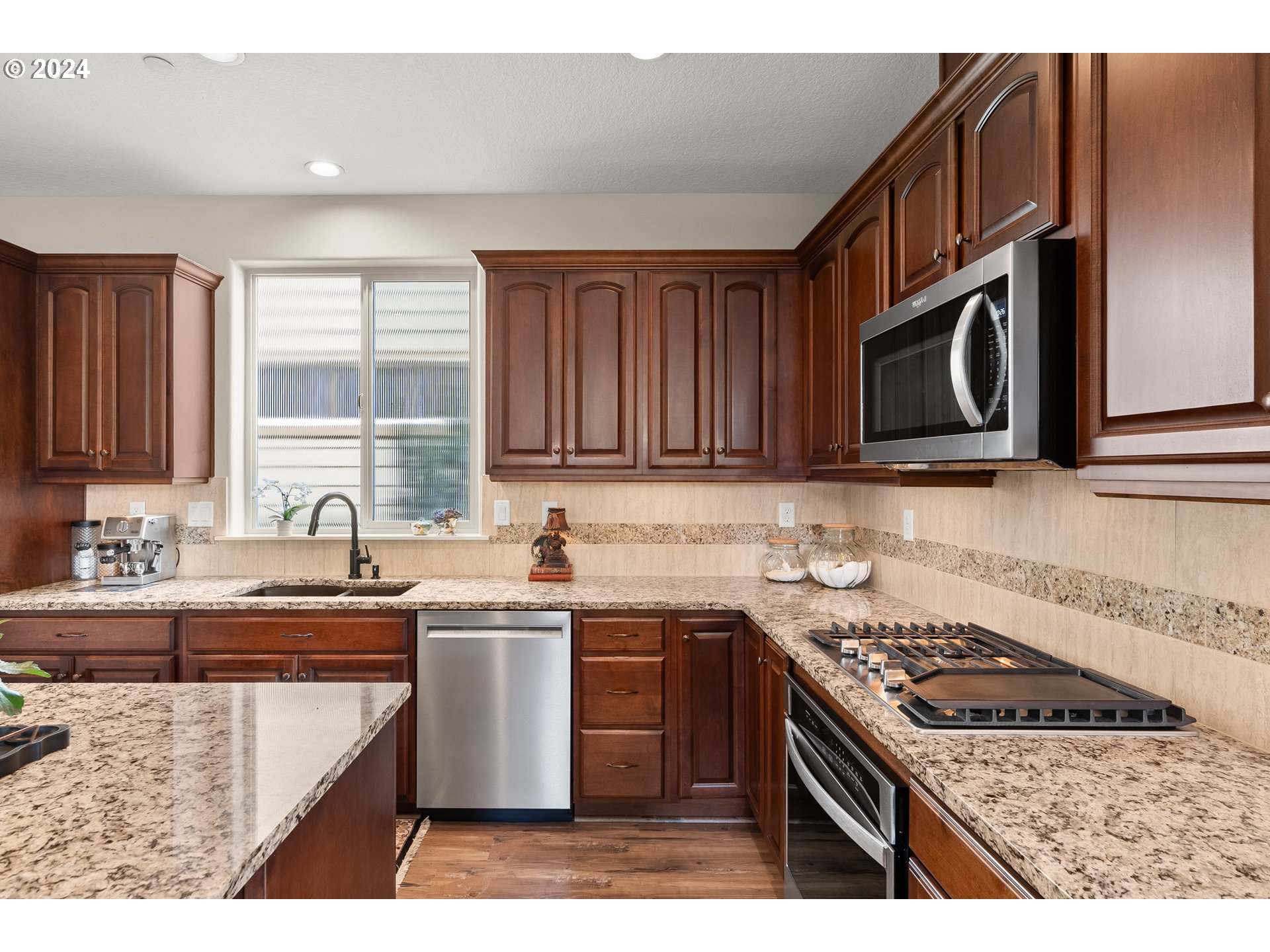 29190 Southwest Serenity Way Wilsonville, OR 97070 - Photo 12 of 40 a kitchen with stainless steel appliances granite countertop a sink stove and cabinets