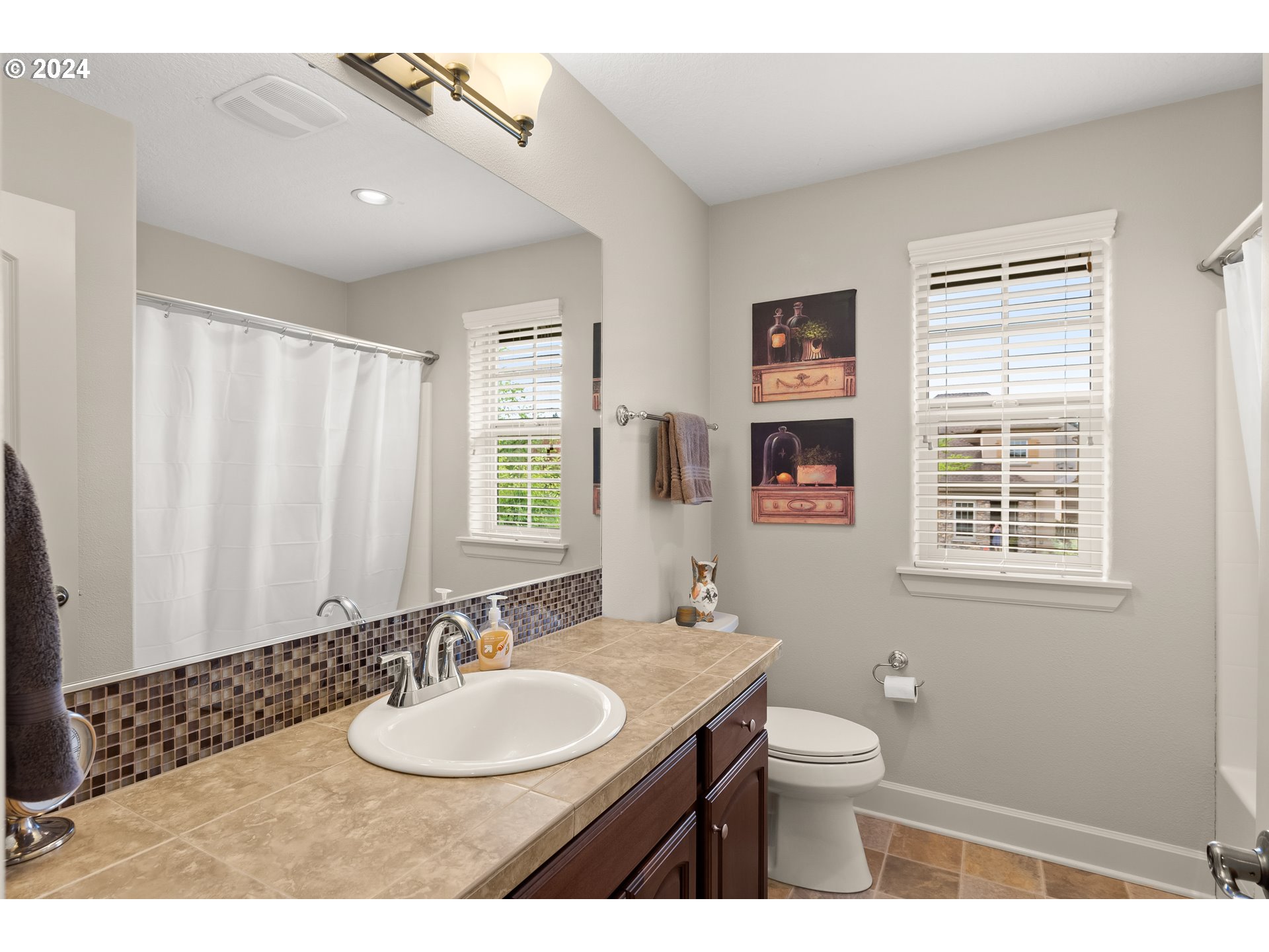 29190 Southwest Serenity Way Wilsonville, OR 97070 - Photo 23 of 40 a bathroom with a granite countertop sink toilet a mirror and shower