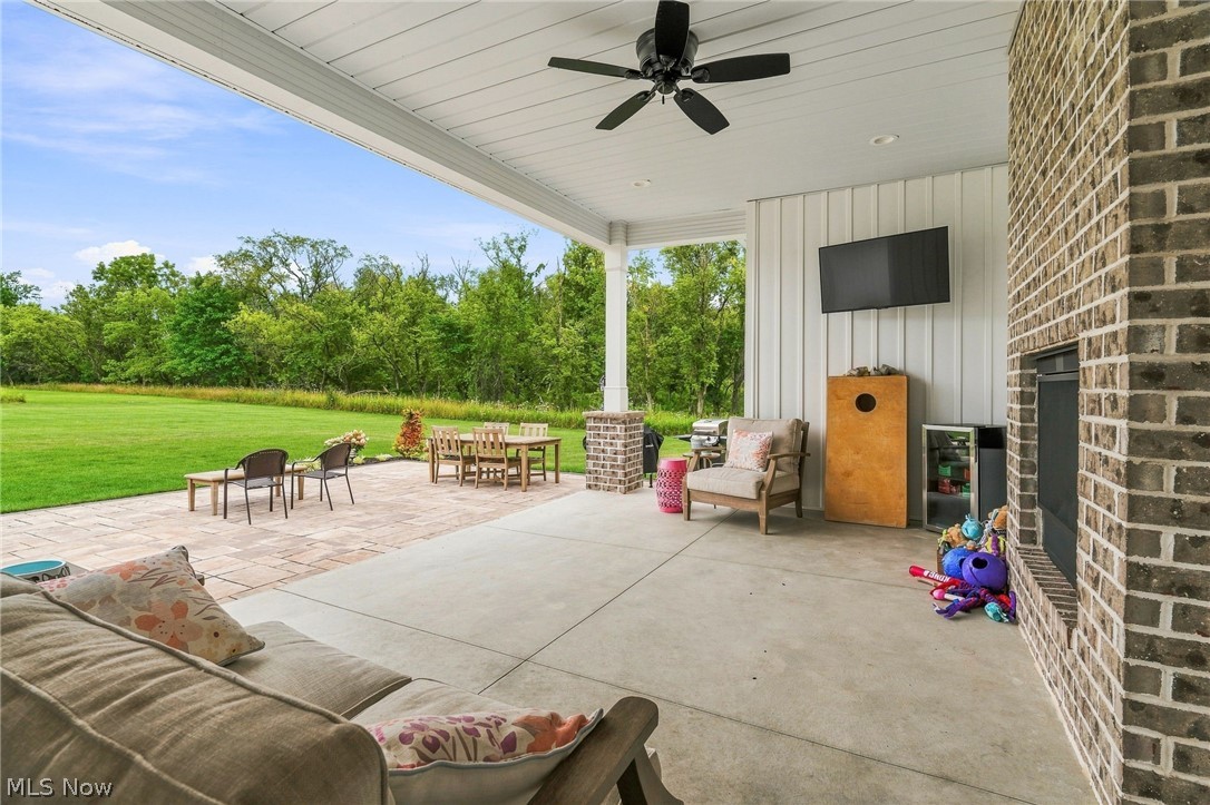 421 Pontius Road Mogadore, OH 44260 - Photo 36 of 50 Expansive covered patio with concrete and paver flooring, overhead ceiling fan, brick fireplace, and integrated outdoor television