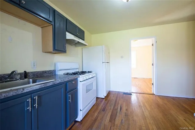 a kitchen with a sink and wooden floor