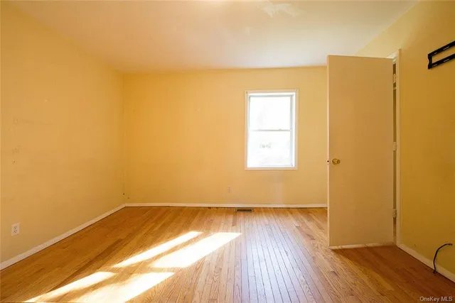 a view of a room with wooden floor and a window