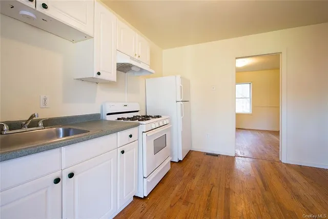 a kitchen with a sink a stove and cabinets