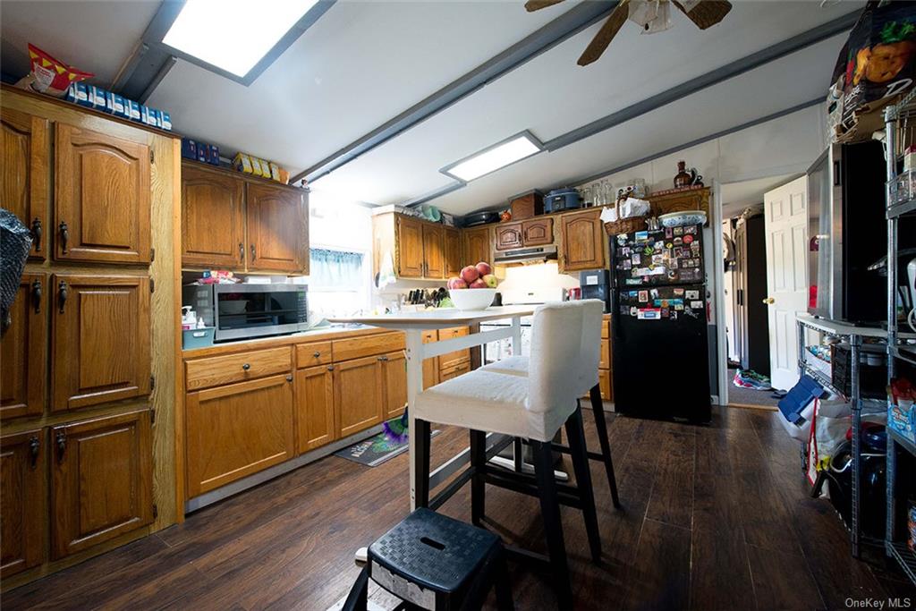 304 Wade Road Liberty, NY 12754 - Photo 32 of 35 a kitchen with stainless steel appliances granite countertop a refrigerator a sink dishwasher a dining table and chairs with wooden floor