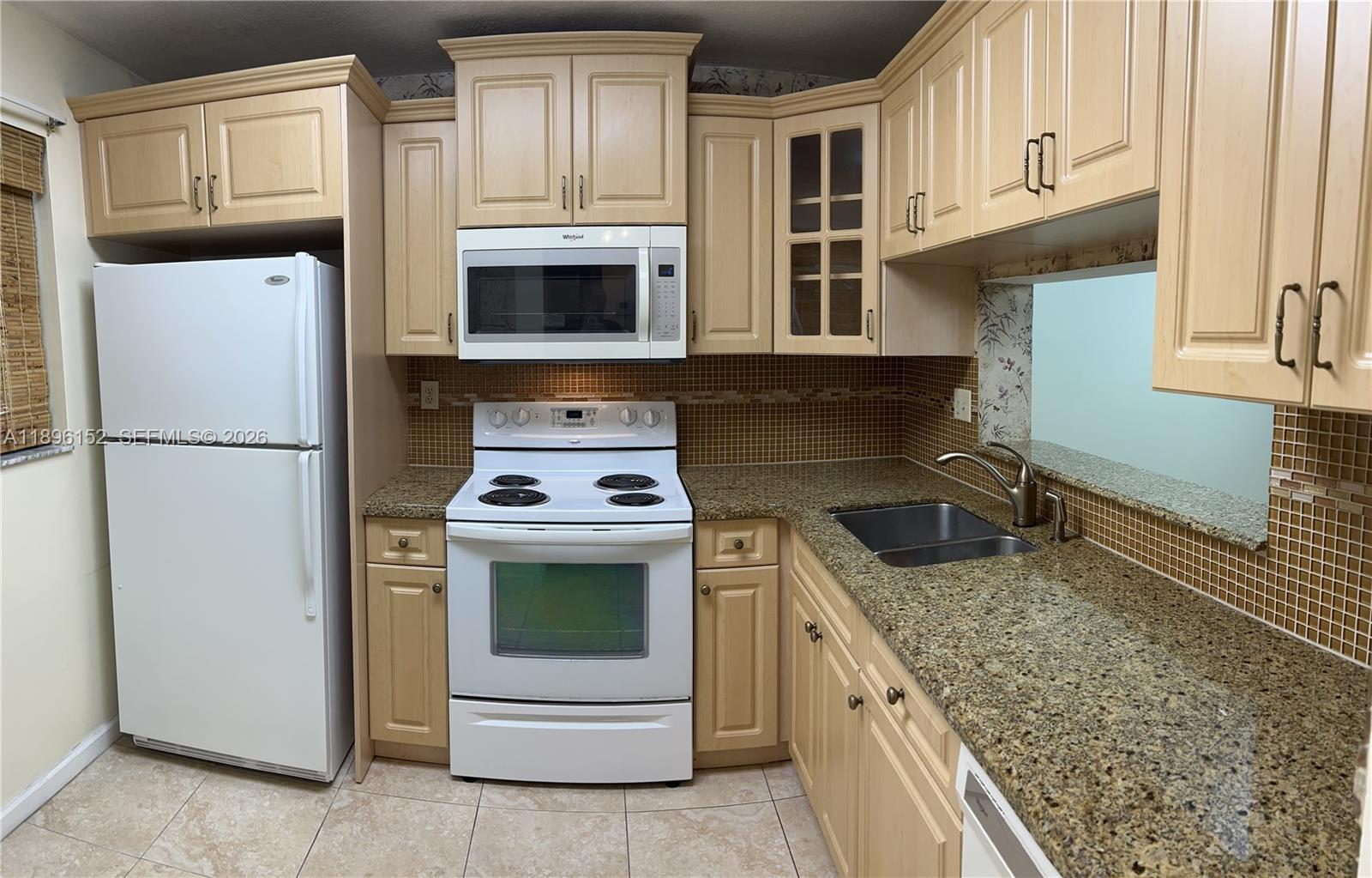10855 Southwest 112th Avenue, Unit 215 Miami, FL 33176 - Photo 38 of 45 a kitchen with granite countertop a sink stove and refrigerator