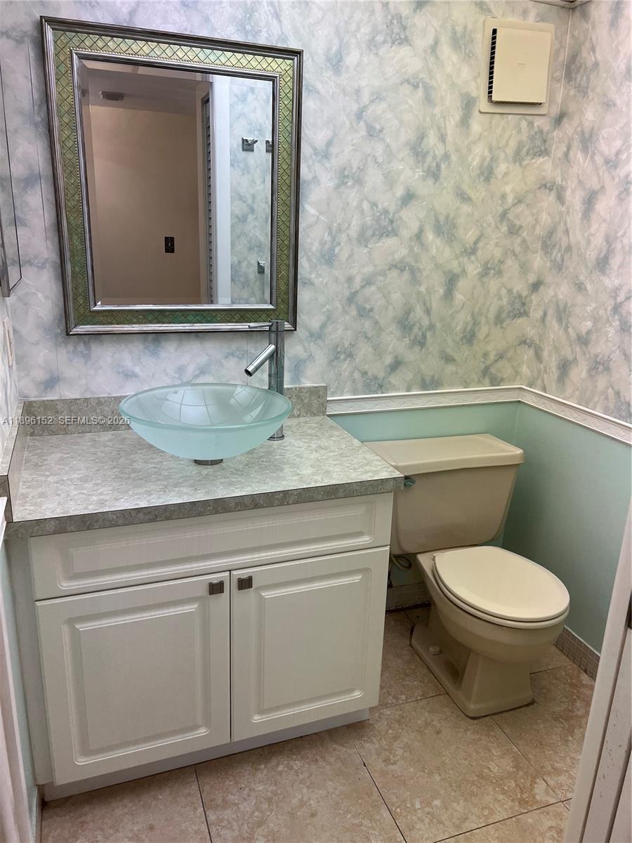 10855 Southwest 112th Avenue, Unit 215 Miami, FL 33176 - Photo 5 of 45 a bathroom with a toilet sink and mirror