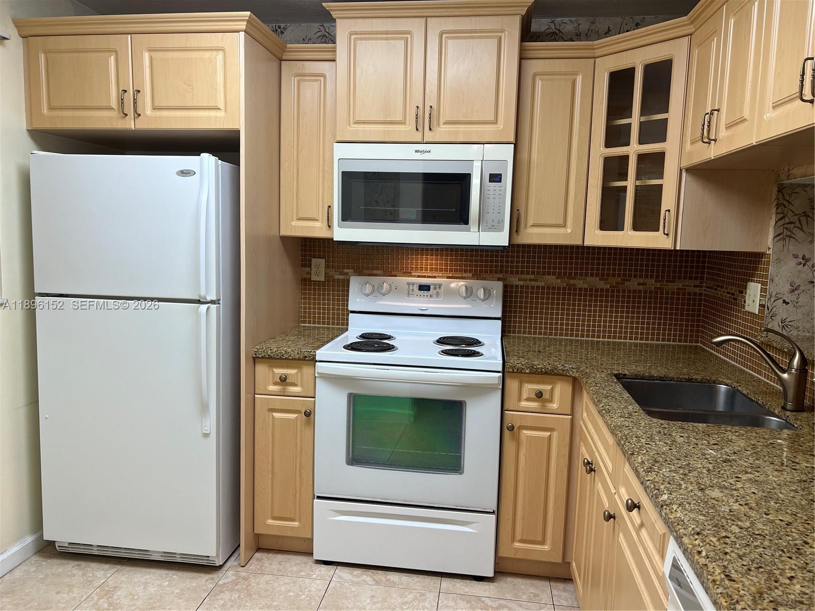 10855 Southwest 112th Avenue, Unit 215 Miami, FL 33176 - Photo 7 of 45 a kitchen with granite countertop white cabinets and white stove