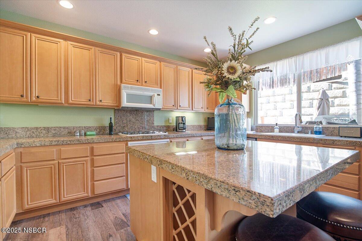 561 Andromeda Drive Lompoc, CA 93436 - Photo 20 of 54 a kitchen with stainless steel appliances granite countertop a sink dishwasher and cabinets with wooden floor