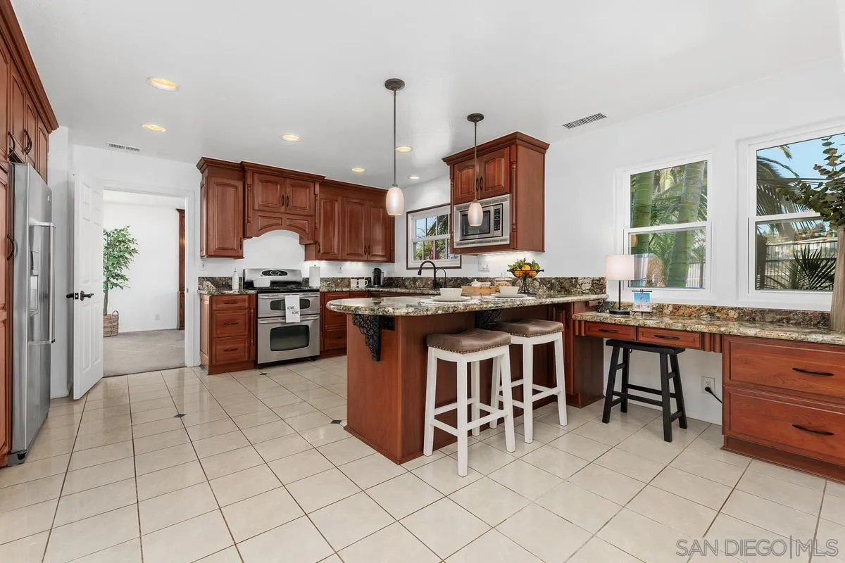 2016 Sequoia Street San Marcos, CA 92078 - Photo 17 of 50 a kitchen with stainless steel appliances granite countertop a stove top oven a sink a counter top space and cabinets