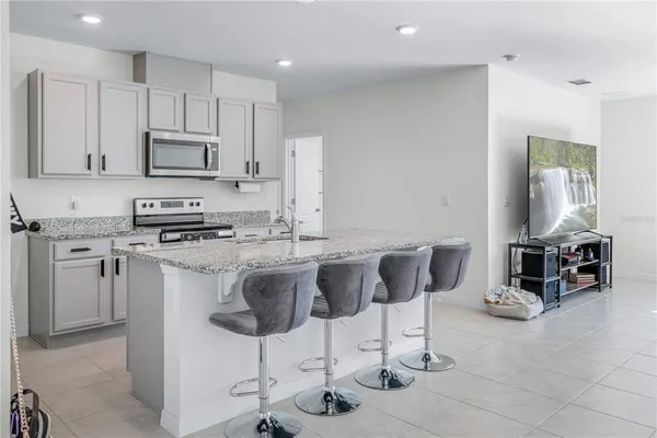 a kitchen with stainless steel appliances a stove a sink a microwave a refrigerator and cabinets