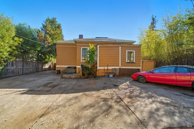 a front view of a house with a yard and mountain view in back