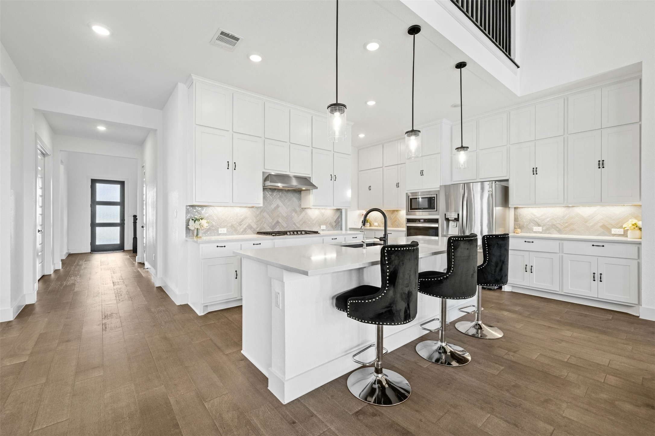 a kitchen with white cabinets and chairs