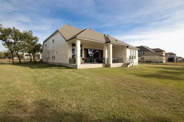 a view of a house with a big yard and large trees
