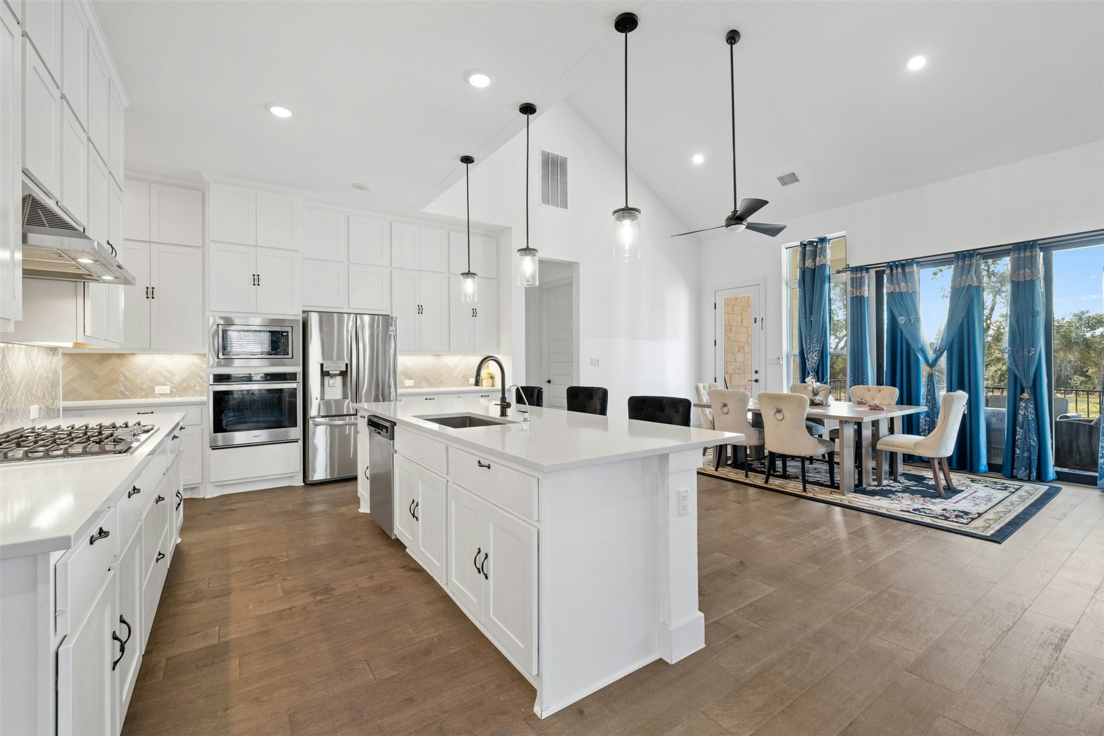 172 Shady Hl Loop Liberty Hill, TX 78642 - Photo 3 of 30 a large kitchen with stainless steel appliances kitchen island granite countertop a lot of cabinets and refrigerator