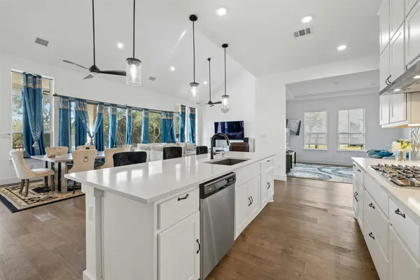 a large white kitchen with lots of counter space sink and appliances